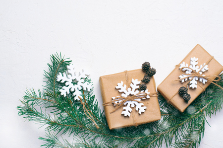 Christmas Gifts with Fir Branches and Wooden Snowflakes on White Backgroundの写真素材