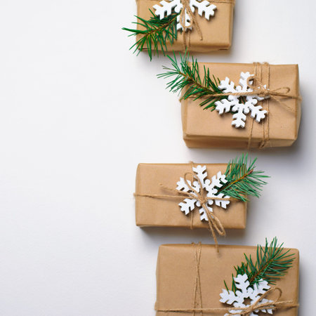 Christmas Gifts with Fir Branches and Wooden Snowflakes on White Background, Winter Holidays Concept