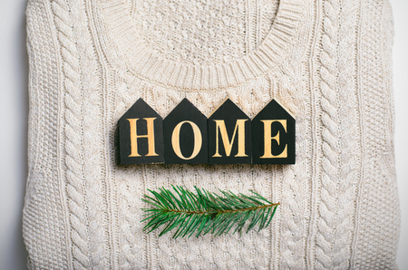 Cozy Home Winter Concept, Home Letters on Beige Knitted Sweater and Fir Branch, Top Viewの写真素材