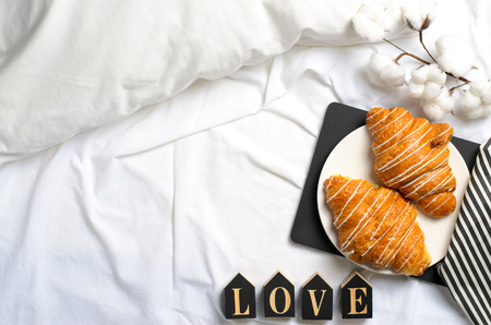Romantic Breakfast in Bed, Croissants, Love Letters on White Bed Sheet, Top Viewの写真素材