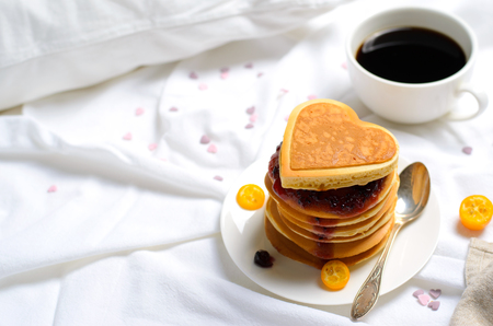 Romantic Breakfast in Bed, Pancakes and Coffee on White Bed Sheet, Top Viewの写真素材