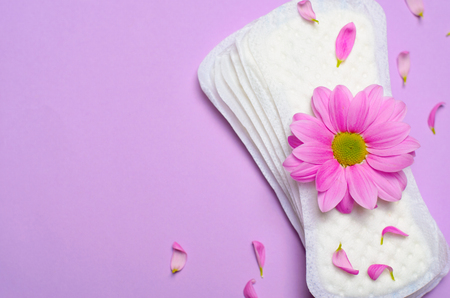 Woman's Sanitary Pads and Gerbera Daisy Flower on Pink Background, Feminine Hygiene Conceptの写真素材