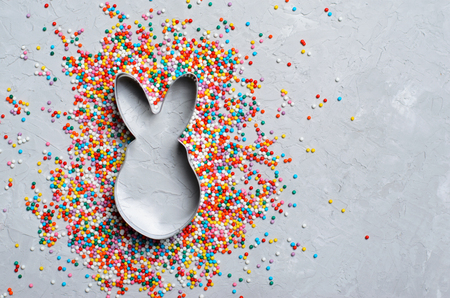 Easter Concept, Sugar Sprinkles and Bunny Cookie Cutter on Grey Background, Sweet Easter Treat, Copy Spaceの写真素材