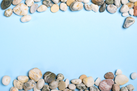 Sea Pebbles over Light Blue Background, Top View, Copy Spaceの写真素材