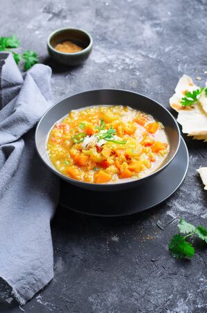 Rice and Pumpkin Indian Soup with Flat Bread on Dark Backgroundの写真素材