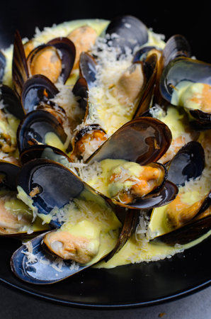 Freshly cooked mussles in wine and creamy sauce in a plate on a table