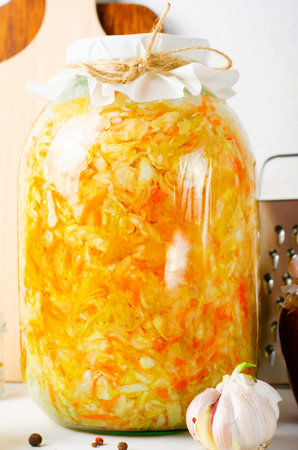 Sauerkraut, Shredded cabbage, apples, and carrots on bright rustic background, Healthy Eating,...
