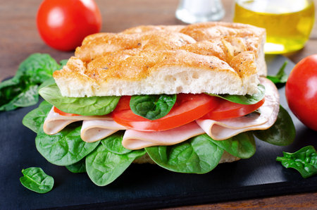 Focaccia Sandwich with Ham, Tomatoes, and Spinach, Sandwich with Italian Flat Bread on Wooden Rustic Backgroundの写真素材