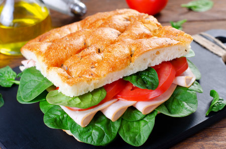 Focaccia Sandwich with Ham, Tomatoes, and Spinach, Sandwich with Italian Flat Bread on Wooden Rustic Backgroundの写真素材