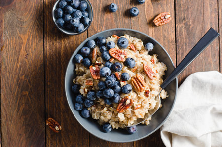 Oatmeal Bowl, Oat Porridge with Blueberry and Pecans on Dark Rustic Background, Healthy Snack or Breakfastの写真素材