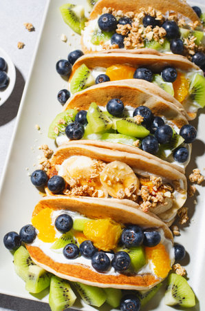 Taco Pancakes with Fresh Fruits, Blueberry and Yogurt Filling, Healthy Breakfast or Snack on Bright Backgroundの写真素材