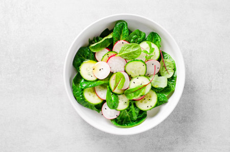 Fresh Salad with Radish, Cucumber and Lettuce on Bright Background, Vegetarian Food, Healthy Eatingの写真素材