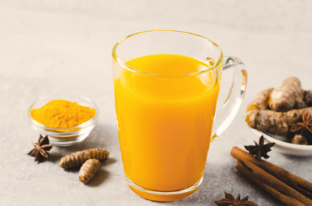 Turmeric Tea, Healthy Beverage with Turmeric and Spices, Jamu Juice, Immunity Booster Drink on Bright Grey Backgroundの写真素材