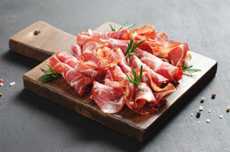 Cured Meat Platter, Antipasto, Appetizer on a Boardover Dark Background