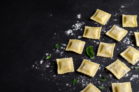 Raw Ravioli with Flour and Basil on Dark Background, Fresh Italian Ravioliの写真素材