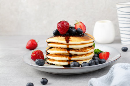 Pancakes with Fresh Berries and Maple Syrup, Tasty Breakfast on Bright Backgroundの写真素材