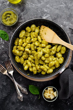 Gnocchi with Pesto, Potato Gnocchi Tossed with Basil Pesto Sauce, Tasty Italian Meal over Dark Backgroundの写真素材