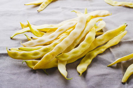 Yellow Wax Beans Ready to Cook, Fresh Long Beans on Beige Linen Background