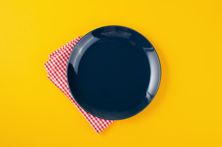 Empty Plate on Bright Yellow Background, Top Viewの写真素材
