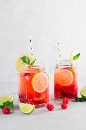 Refreshing Cold Cocktail or Mocktail with Berries and Lime, Raspberry Lemonade on Bright Backgroundの写真素材