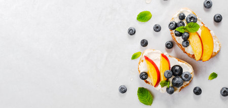 Homemade Toast with Blueberry, Peach and Cream Cheese, Delicious Snack or Breakfast on Bright Backgroundの写真素材