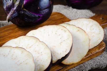 Fresh Sliced Eggplants over Dark Wooden Rustic Backgroundの写真素材