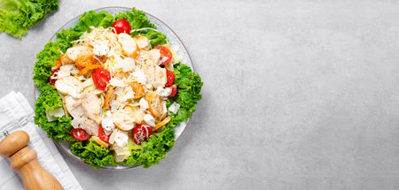 Caesar Salad, Fresh Salad with Grilled Chicken Breast, Croutons, Parmesan Cheese, Cherry Tomatoes, Lettuce and Dressing over Bright Concrete Backgroundの写真素材