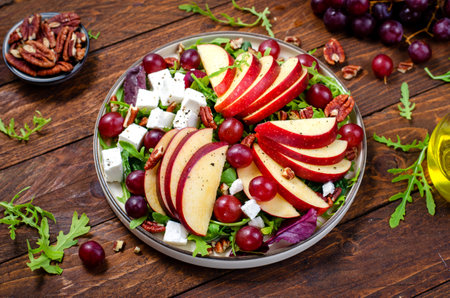 Fresh Apple Salad with Grapes, Pecans, Arugula and Feta, Fall Salad on Wooden Background, Comfort Foodの写真素材
