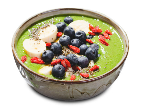 Healthy Green Smoothie in a Bowl with Banana, Blueberry, Goji, and Chia Seed Toppings on White Isolated Backgroundの写真素材
