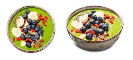 Healthy Green Smoothie in a Bowl with Banana, Blueberry, Goji, and Chia Seed Toppings on White Isolated Backgroundの写真素材