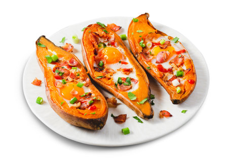 Baked Sweet Potato Stuffed with Egg, Bacon, and Green Onions on a Plate on White Isolated Backgroundの写真素材