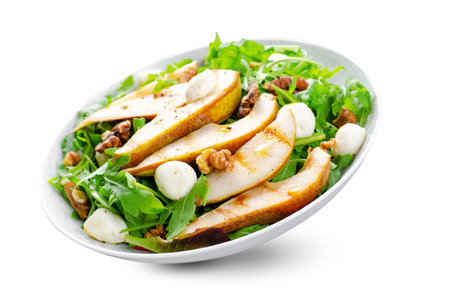 Grilled Pear Salad, Fresh Salad with Pear, Arugula, Mozzarella Pearls, Walnuts and Honey Dressing on White Background Isolatedの写真素材
