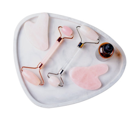 Rose Quartz Roller and Gua Sha Tool, Facial Lifting Scraping Massage Treatment on White Isolated Backgroundの写真素材