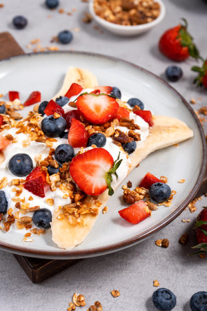 Healthy Banana Split Breakfast, Banana Topped with Yogurt, Granola and Fresh Berriesの写真素材