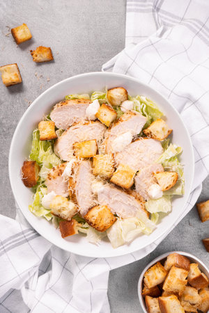 Chicken Caesar Salad in a Bowl with Parmesan Cheese, Lettuce, Dressing and Croutonsの写真素材