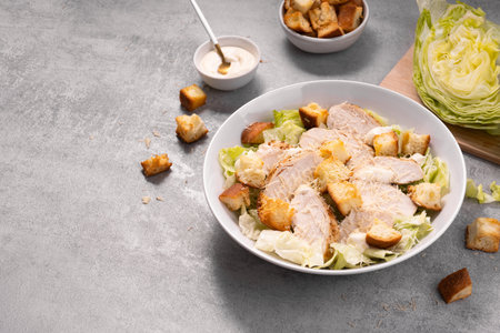 Chicken Caesar Salad in a Bowl with Parmesan Cheese, Lettuce, Dressing and Croutonsの写真素材