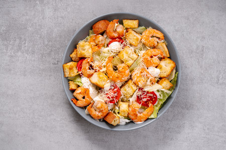 Shrimp Caesar Salad in a Bowl with Parmesan Cheese, Lettuce, Dressing and Croutonsの写真素材