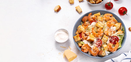Shrimp Caesar Salad in a Bowl with Parmesan Cheese, Lettuce, Dressing and Croutonsの写真素材
