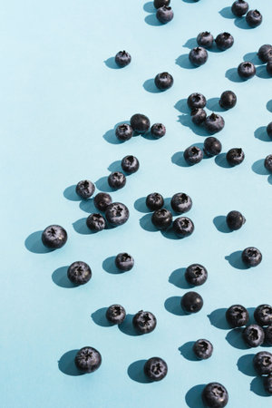 Many Blueberries on blue background. Closeup still life pattern. Fresh ripe healthy fruit harvest....