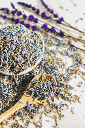 Dry lavender in spoon on wooden table. Herbal drink. Beauty cosmetic, perfume ingredient. Relaxation beverageの写真素材