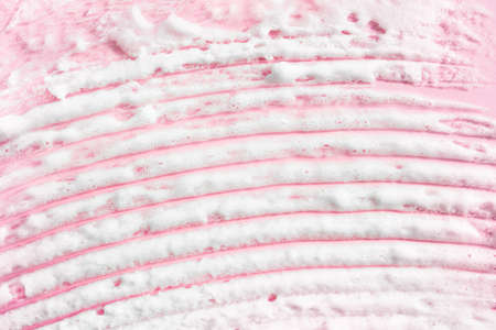 White smear of foam on pink background. Creme, shaving foam, mask, beauty product swatch closeup.の写真素材