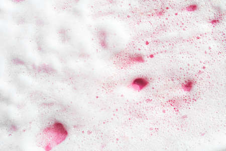 Textured smear of white creamy foam on pink background. Abstract swatch of cosmetics facial, body care. Beauty selfcare banner.の写真素材