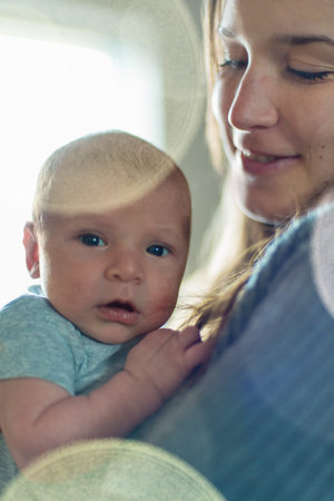 Selective focus portrait of a baby boy on his mother shoulder