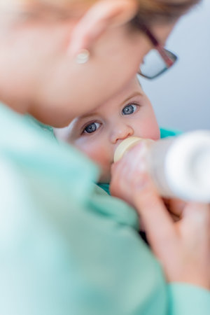 Mother feeding milk to a hungry toddler