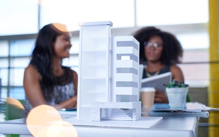 Couple of business coworkers collaborating on a project in a bright glass officeの写真素材