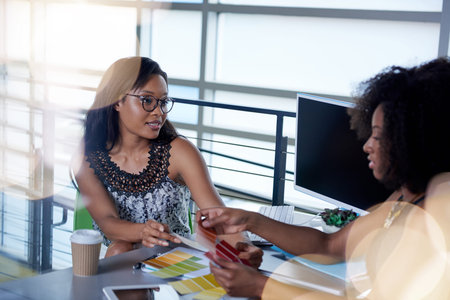 Couple of business coworkers collaborating on a project in a bright glass officeの写真素材