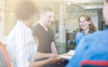 Candid picture of a business team collaborating. Filtered serie with light flares and cool tones.の写真素材