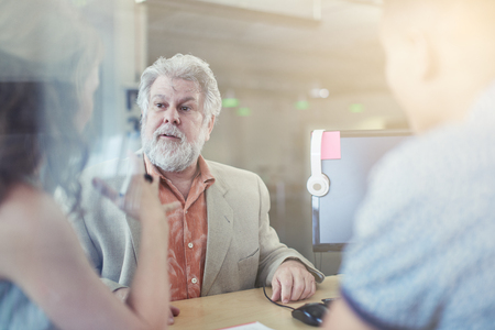 Candid picture of a business team collaborating. Filtered serie with light flares and cool tones.の写真素材