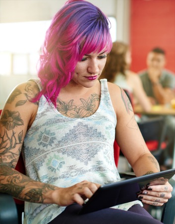 Casual portrait of a business woman using technology in a bright and sunny startup with the team in the backgroundの写真素材
