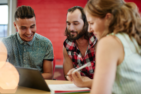 Candid picture of a business team collaborating. Filtered serie with light flares and cool tones.の写真素材